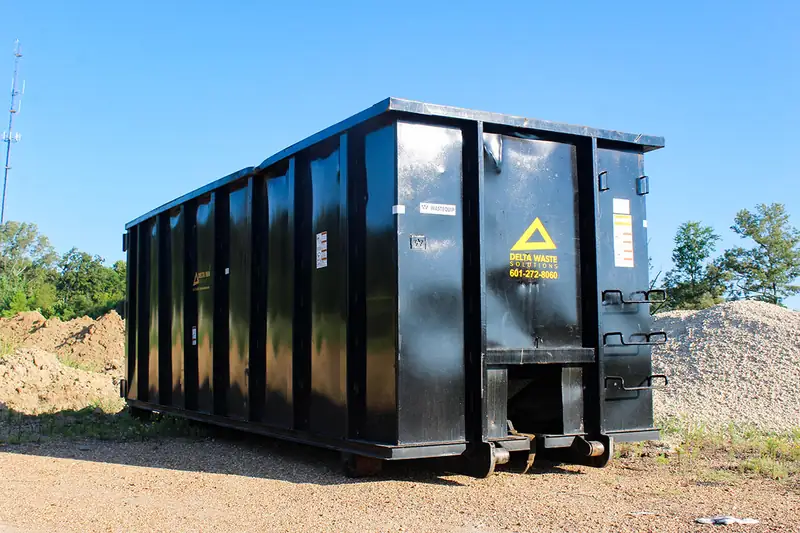 Black Delta Waste Solutions roll-off dumpster on a construction site